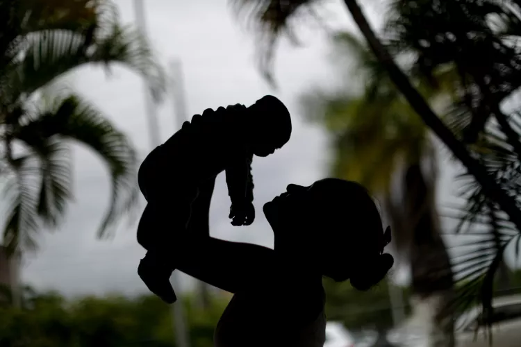 Alice,15 years old, holds her a 4-month old baby born with microcephaly in Recife