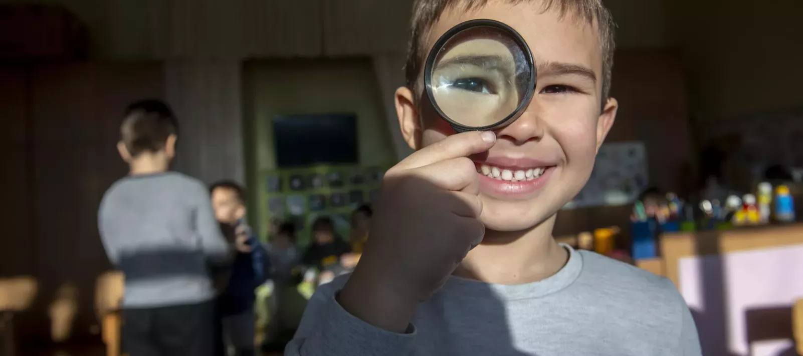child with magnifying lens