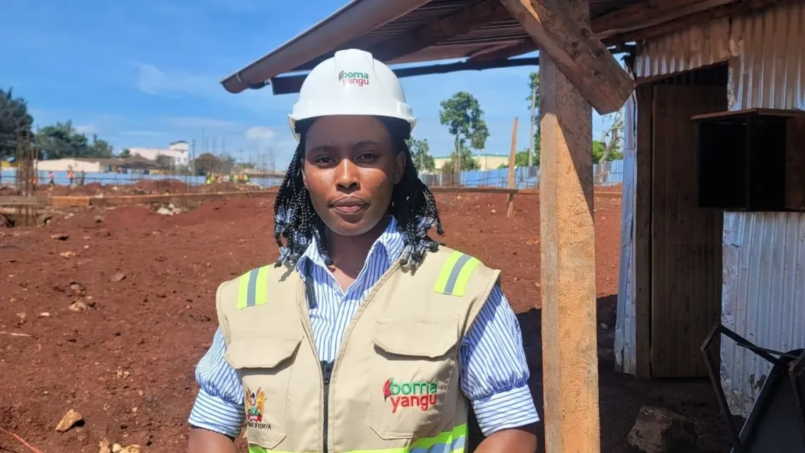 A woman wearing a white helmet and a field jacket.