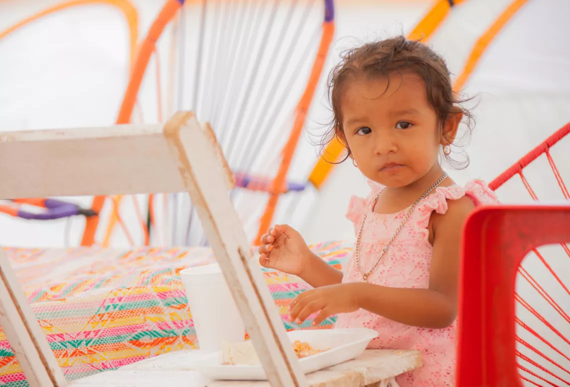 A girl eats breakfast inside a temporary shelter where she was being cared for by other adults in Juchit&aacute;n, Oaxaca, Mexico.