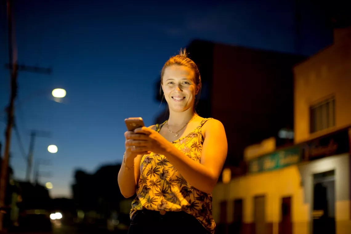 Jessica Marques, 20, holds her mobile phone on a street in Taiobeiras municipality in the Southeastern state of Minas Gerais, Brazil.