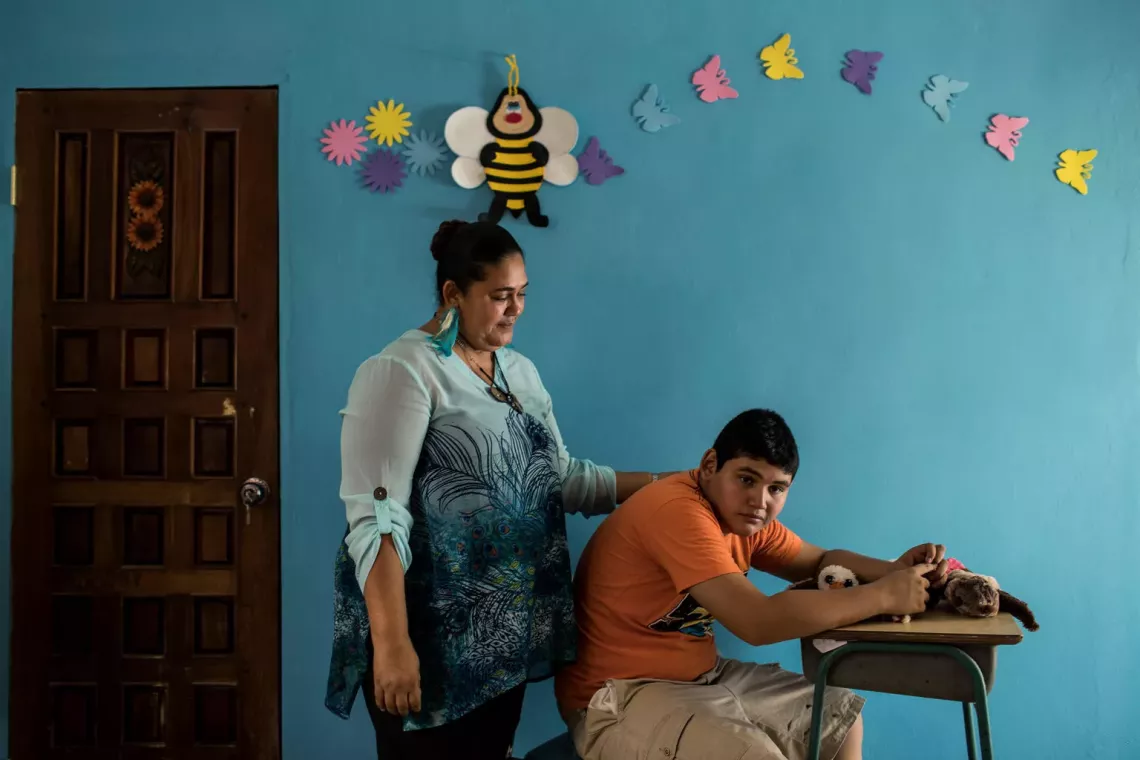 On 27 August 2018 in Puerto Cortes, Cortes, Honduras, Jose Angel Aguila Lizama (right), 14, who is autistic, sits at home with his mother, Lourdes Lizama. Jose Angel has been the victim of bullying since his first years of school 