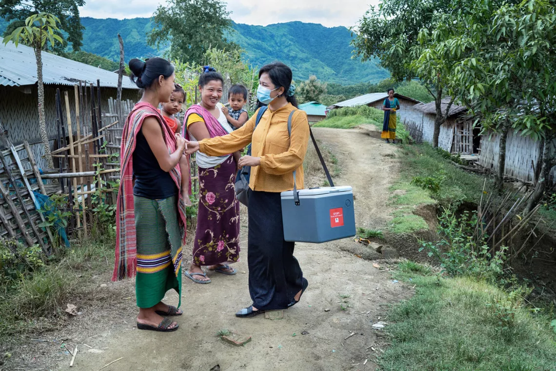 in Robertpara, a village in Thanchi, Bandarban District, Bangladesh, volunteer health worker, Mahainue Marma, (orange top) is running a vaccination session for parents to bring their children for routine immunizations.