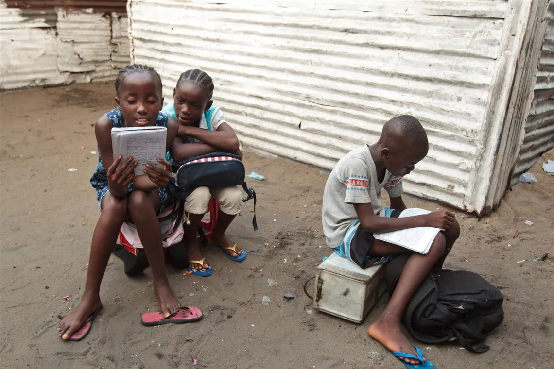 Children study outside dwellings in the overcrowded WestPoint slum neighbourhood in Monrovia