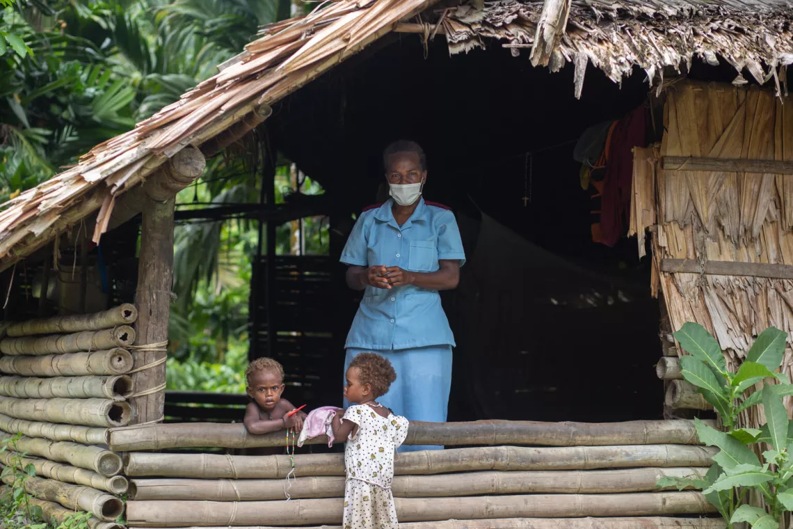 Nurse Rosemary Raikekeni speaks to children while washing her hands during a visit to bring COVID-19 vaccines and other essential health services to remote Kuvamiti village in East Guadalcanal, Solomon Islands.