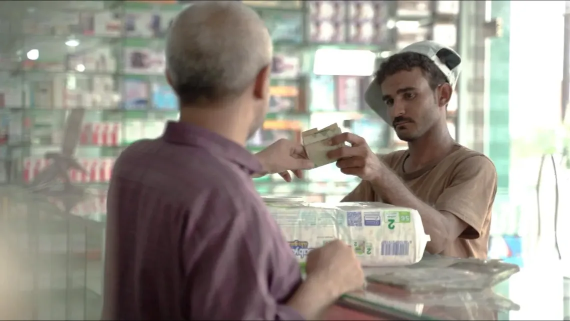 A parent using their cash transfer