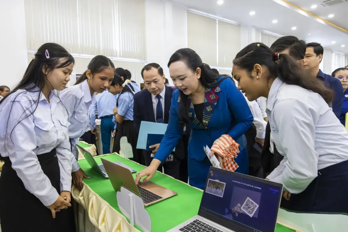 young girls showing off a game to a government official