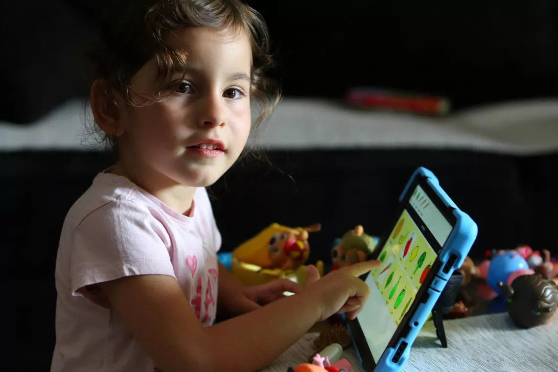 Four-year-old Srna using a Cboard Communicator that helped her start pronouncing understandable syllables for the first time.