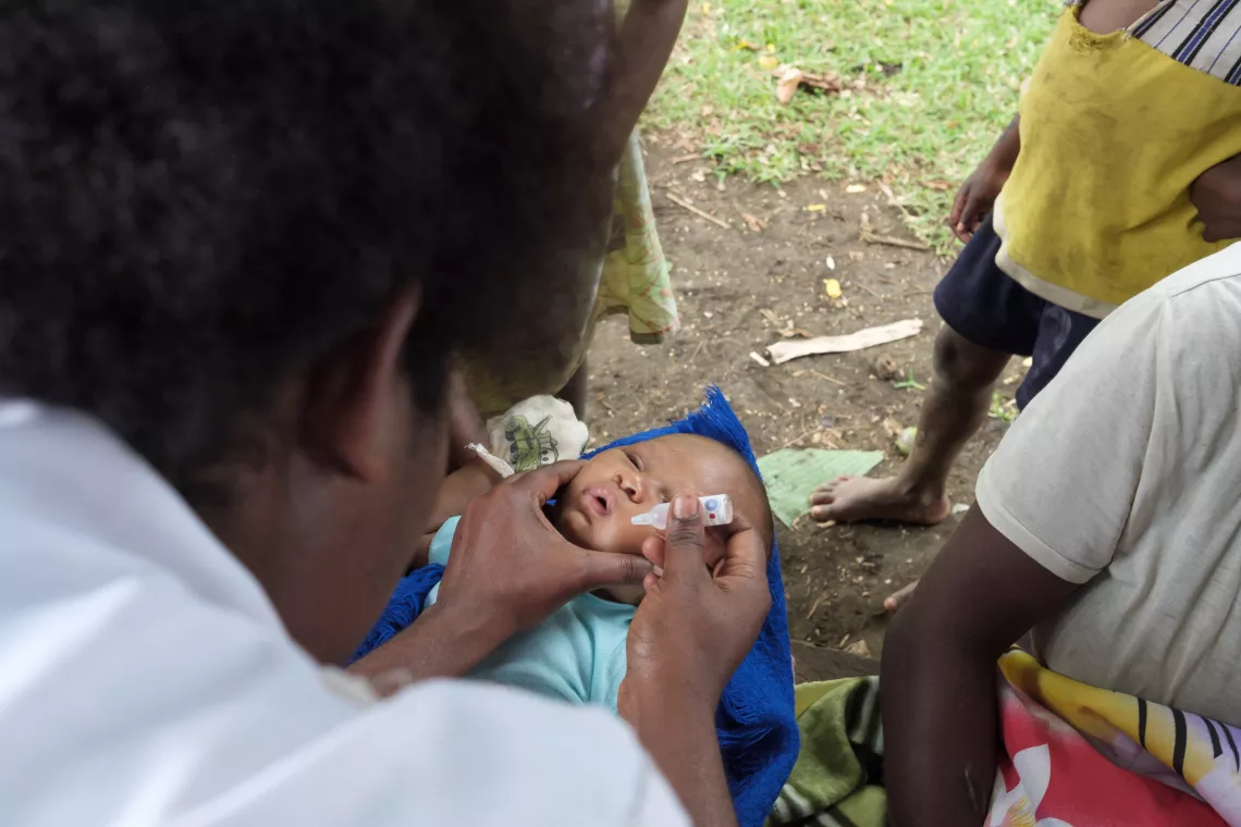 After carrying a precious cargo of vaccines on a 3 hour hike, Midwife Roslinda Narwayen, from the Vaimali Health Centre, Epi Island conduct vaccinations at Ngala village on the southern coast of Epi Island, Vanuatu.