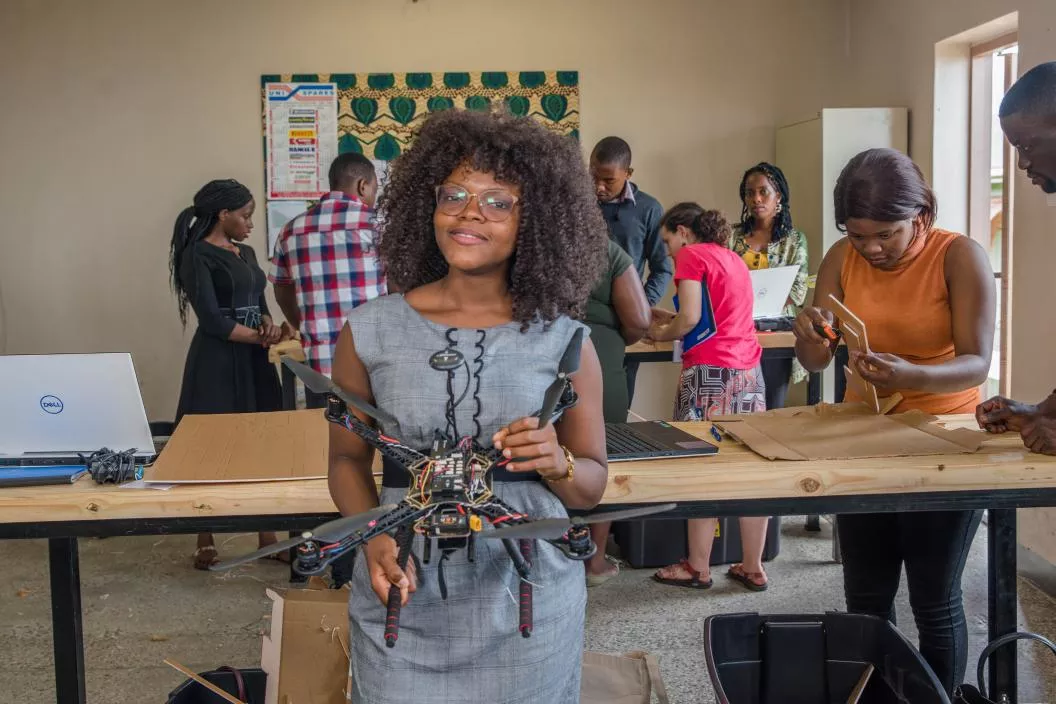 Woman posing to the camera holding a drone