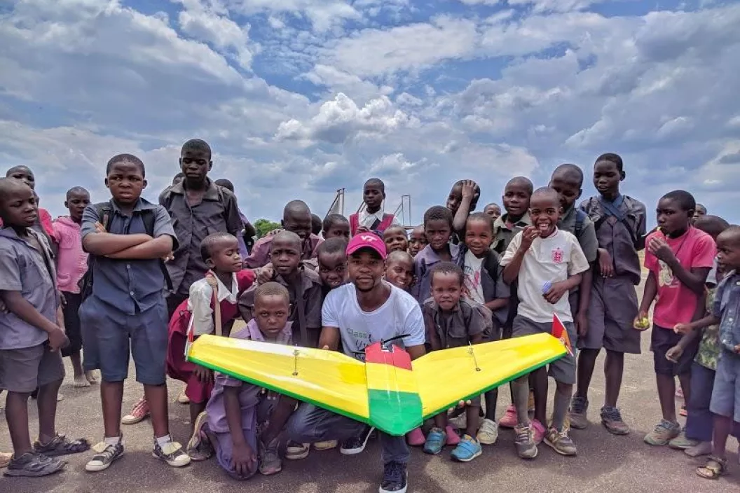 University student poses with school children at Kasungu Drone Corridor.