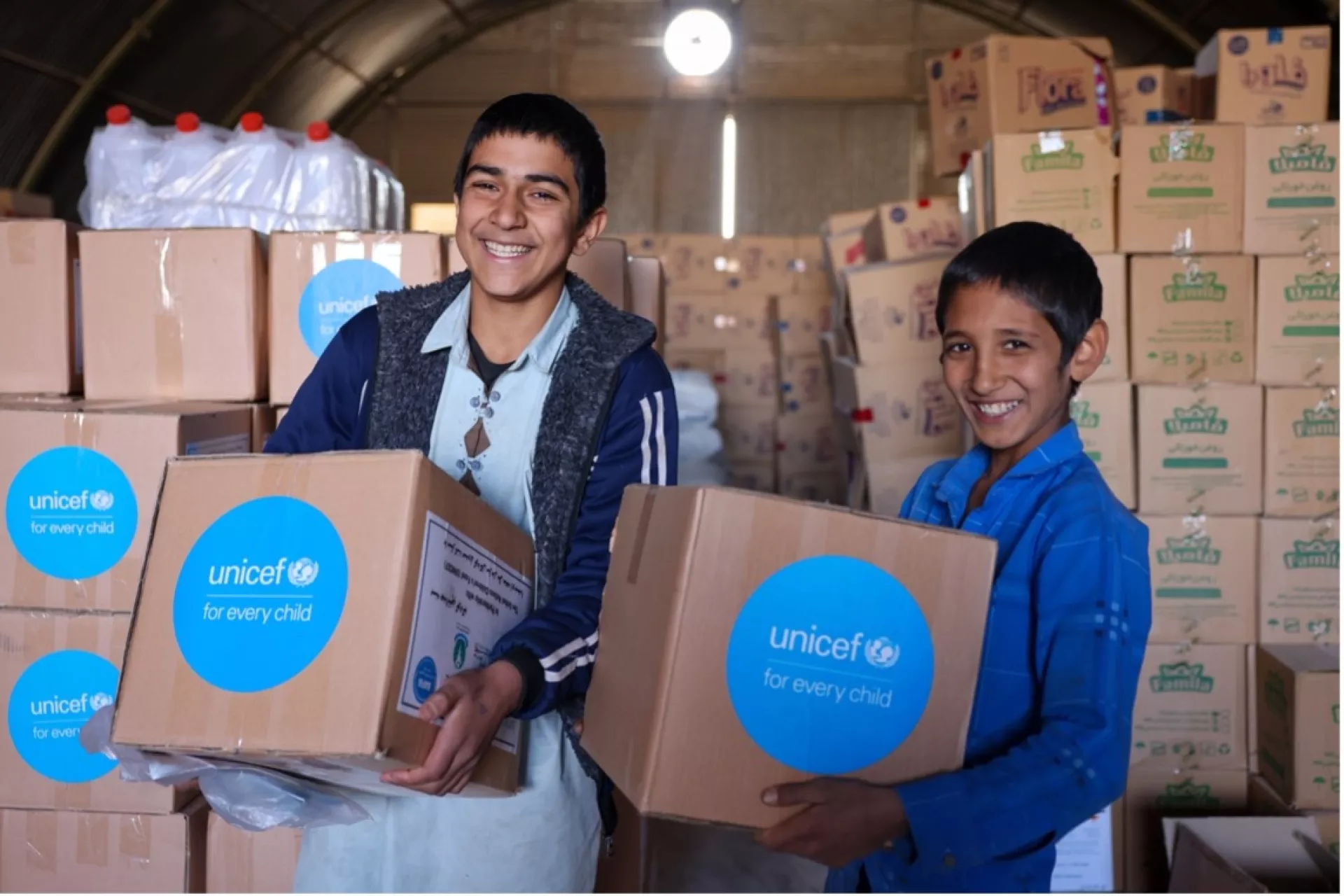 Two Afghan refugee children in a settlement have received nappy kits for younger members of their families, Markazi province, Iran.