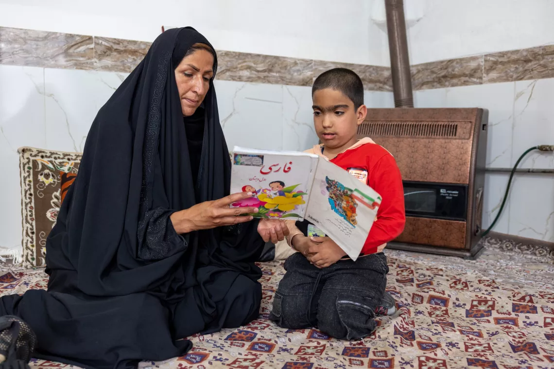 Ali Asghar, seven years old, and his remedial class teacher working on their Farsi lessons, Torbate Jam, Khorasan Razavi, Iran.