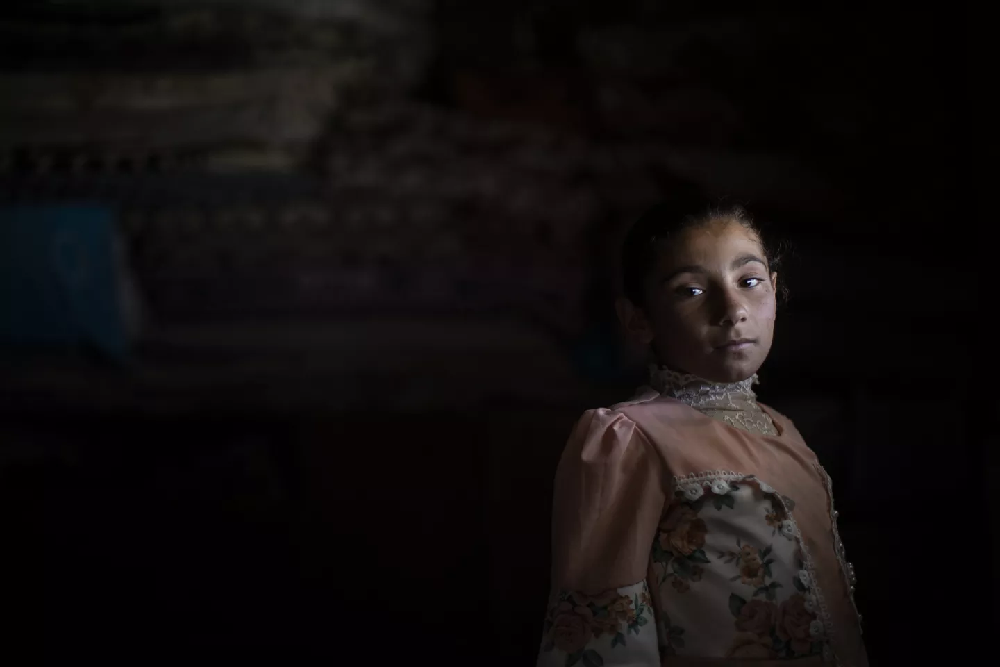 On May 17, 2023, Ashwaq, 10, from a village between Nineveh and Salah al-Din, poses for a portrait inside her home located at Hassansham U2 IDP camp. She has been living in Hassansham camp since 2019. 