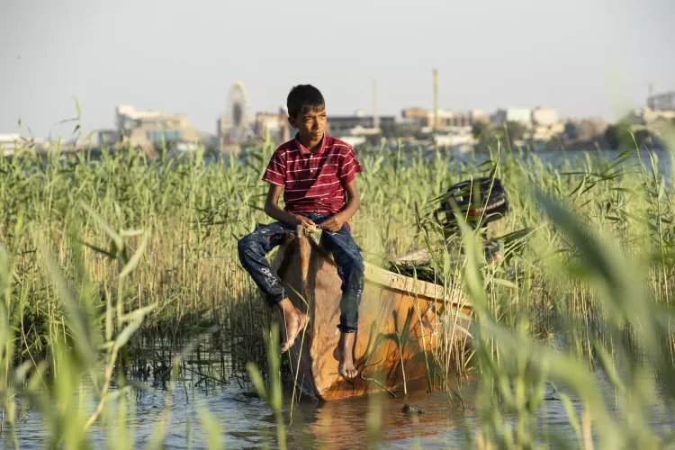 Child sits in his father boat in the marshes Nasiriyah government, Iraq  