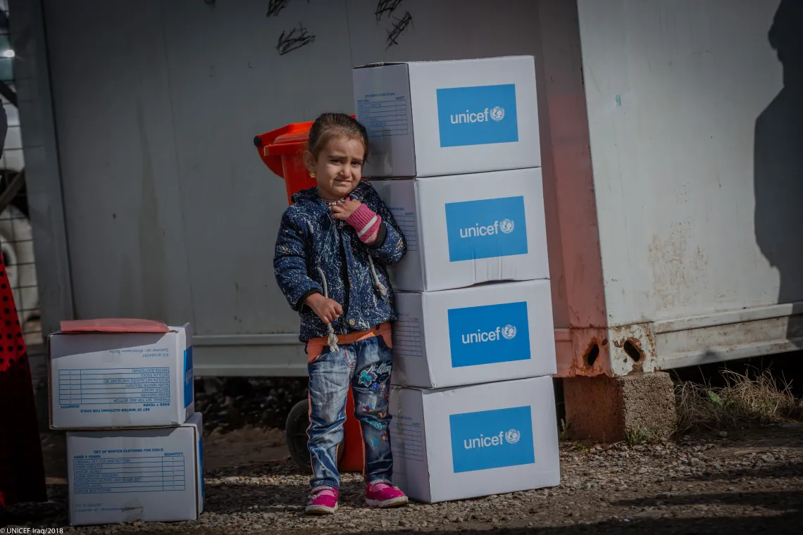 Farah stands near winter boxes, in Qadiya camp in Dohuk