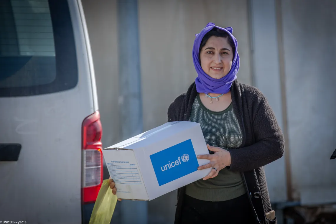 Nisreen from Qadia camp with her son&rsquo;s winter clothes box