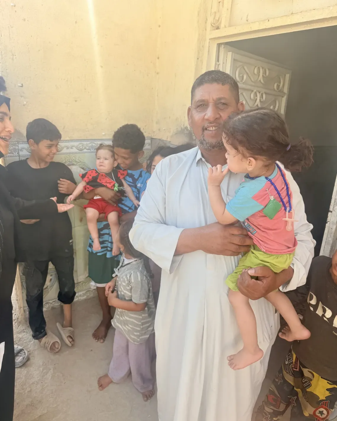 Abed Jassim stands near his home in Al-Diwaniyah. He supports a household of 12 in a community where some families wait days or weeks for water, making it harder to meet basic needs and earn a steady income.  