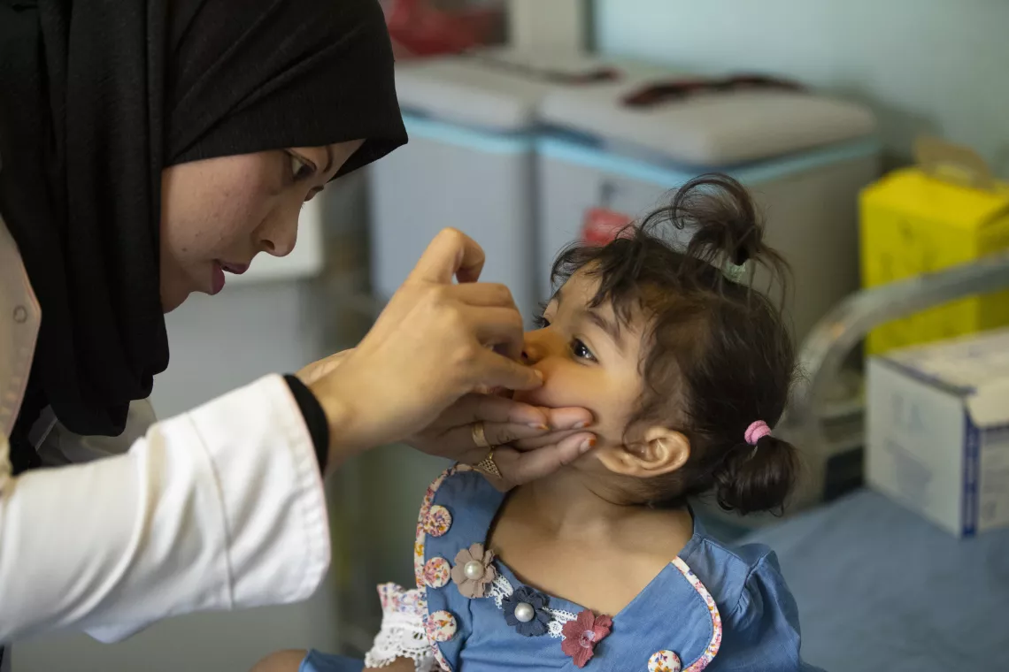 Rawan Abbas Khalid, five-months-old girl is taking her vaccine at Al Shuaiba Primary Health Care Center. 