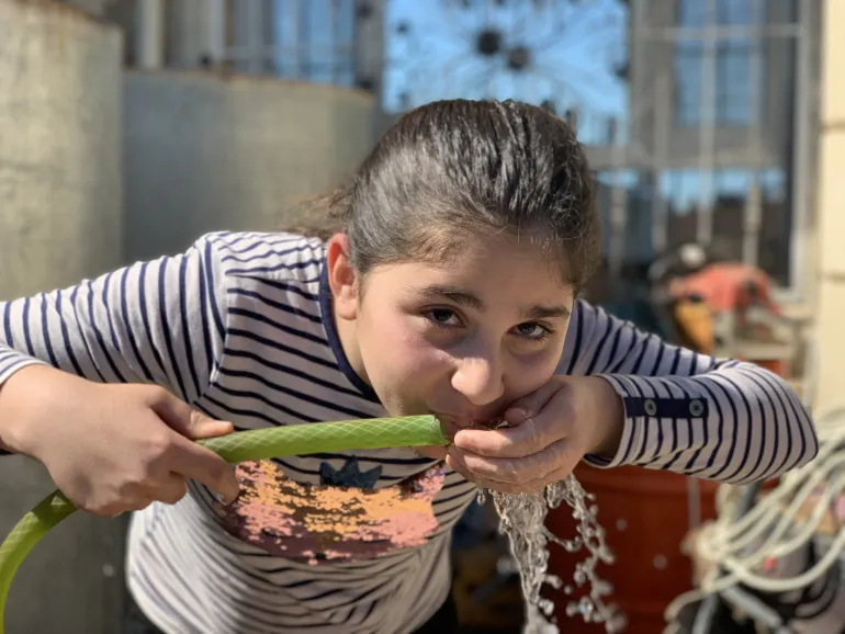 A girl drinks water in Iraq