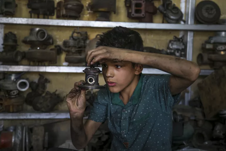 Karrar, 14, works at a car repair shop in Baghdad