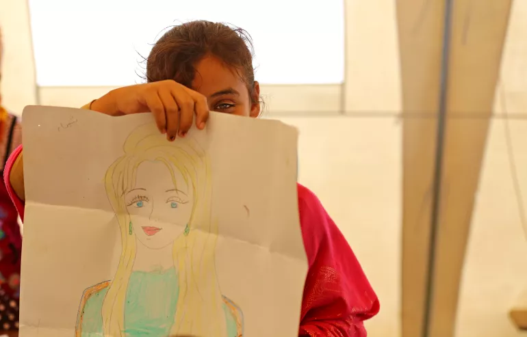 فتاة تمسك برسمتها