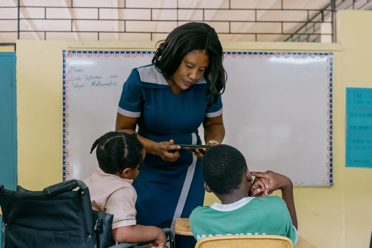 Teacher with two students and a digital device