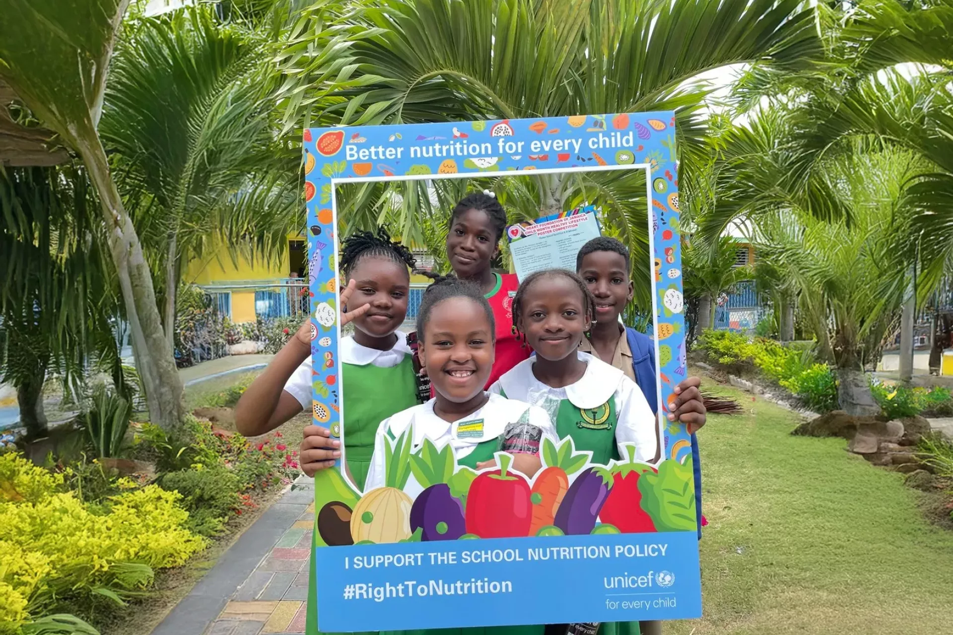Children holding up a sign supporting the School Nutrition Policy