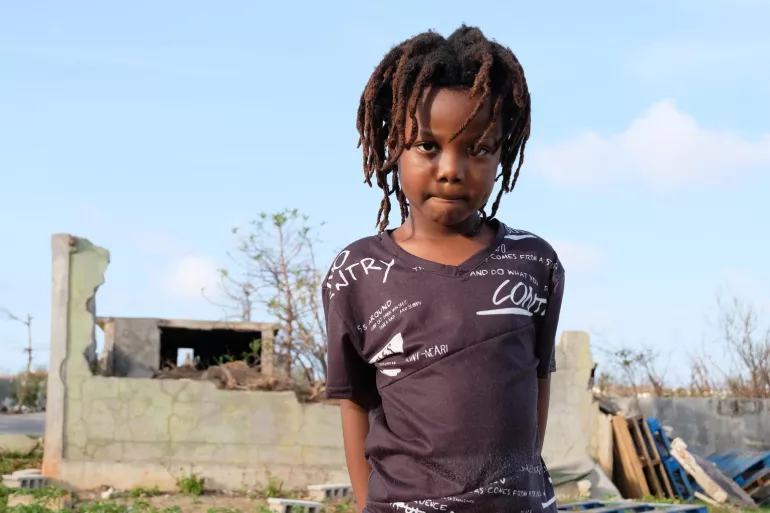 On 11 September, TJ Hickson, 5, stands outdoors near a partially destroyed brick building, in South Hill District, on the island of Anguilla – which was hard hit during Hurricane Irma.