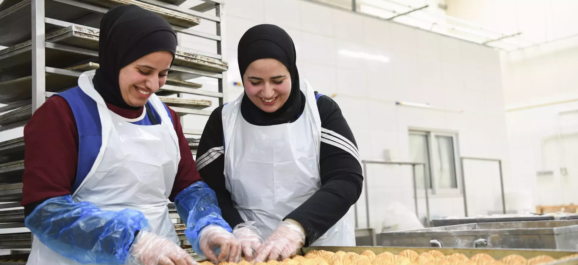 Two young women working in a sweets factory.