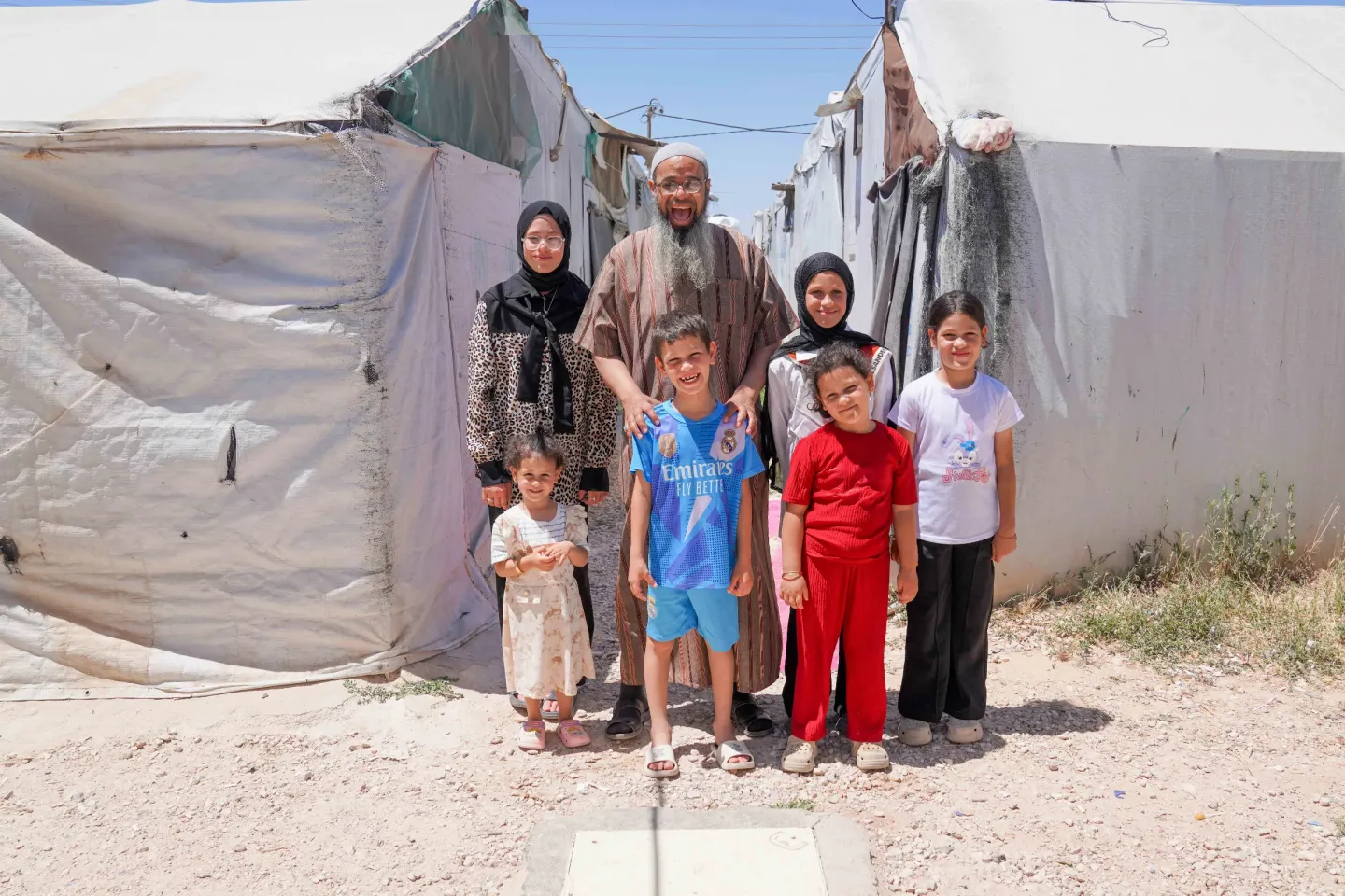 Abu Sham posing for a photo with his children in Garden Camp/ Jordan