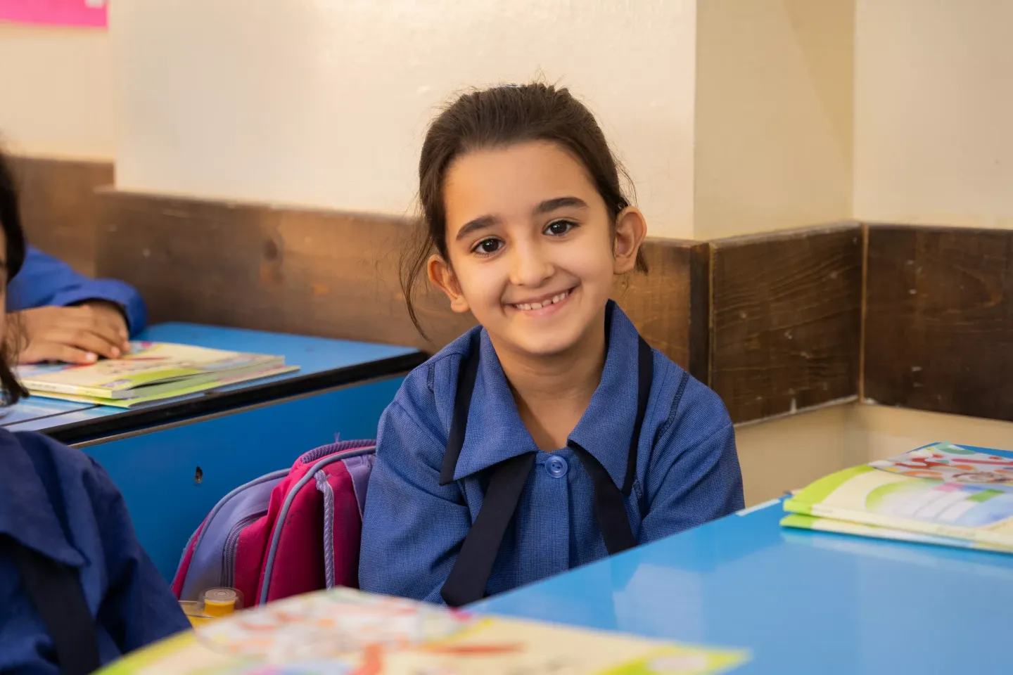 A girl sitting on a school desk.