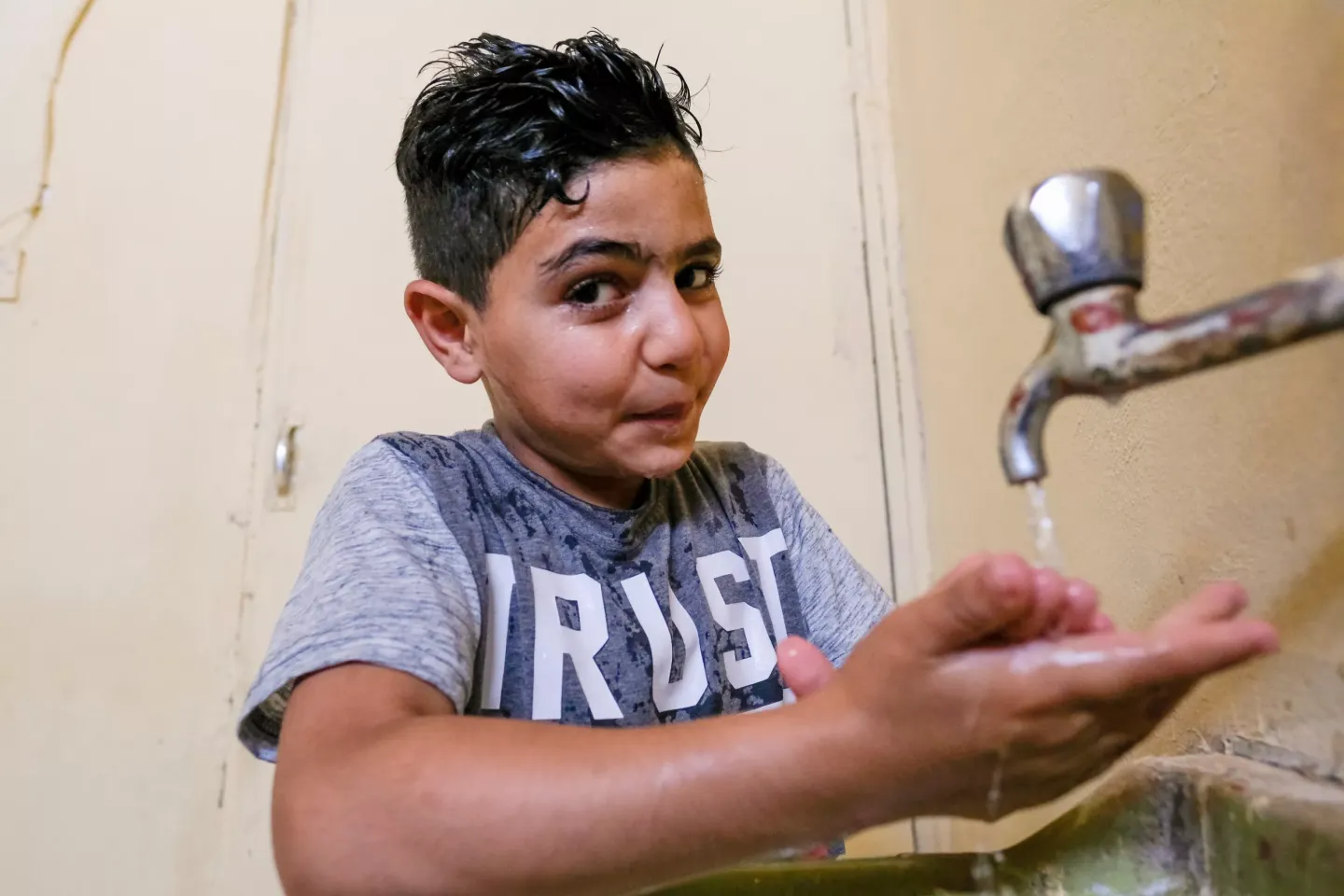 A boy washing his hands.