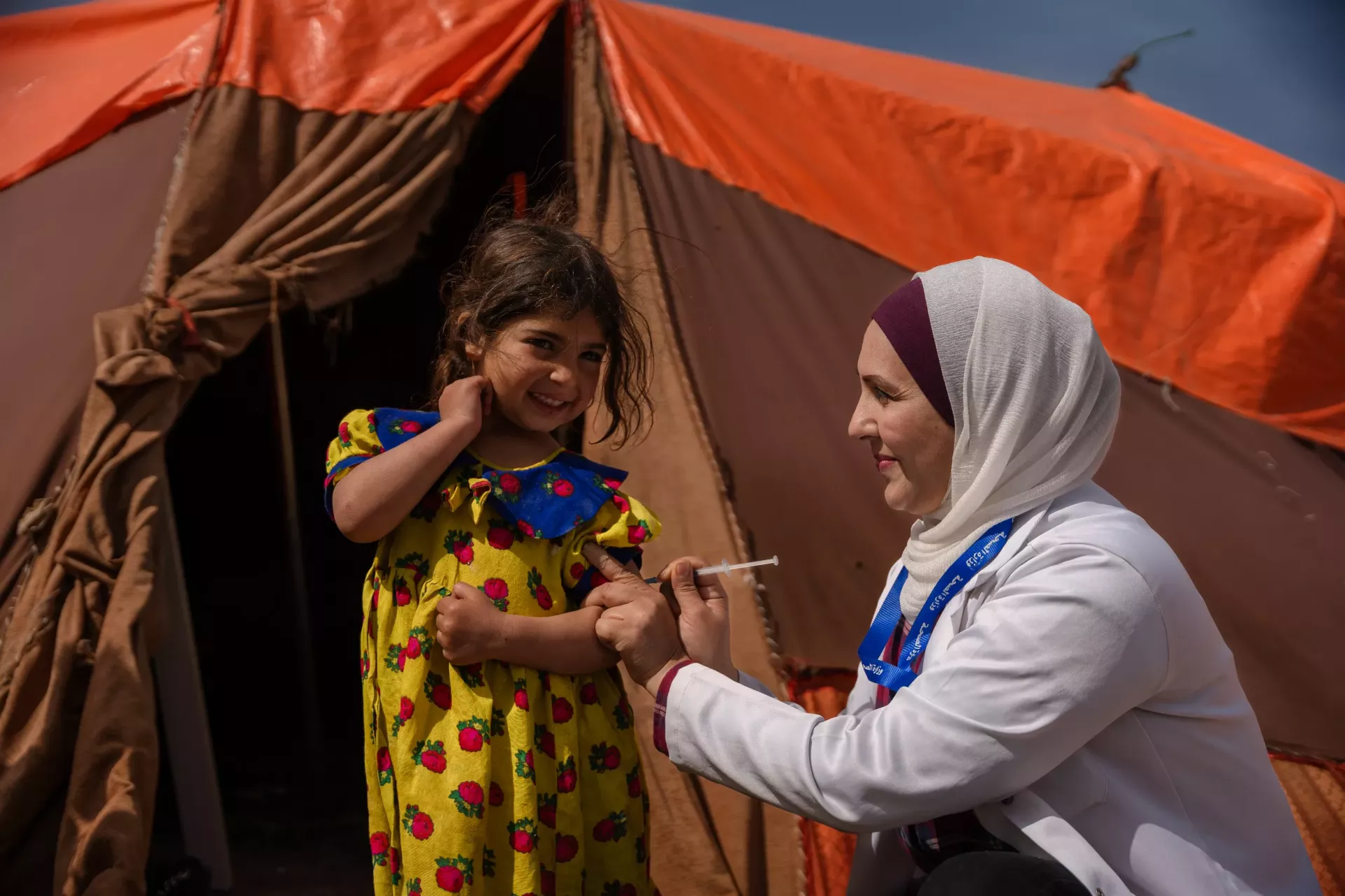 A healthcare worker vaccinating a girl child.