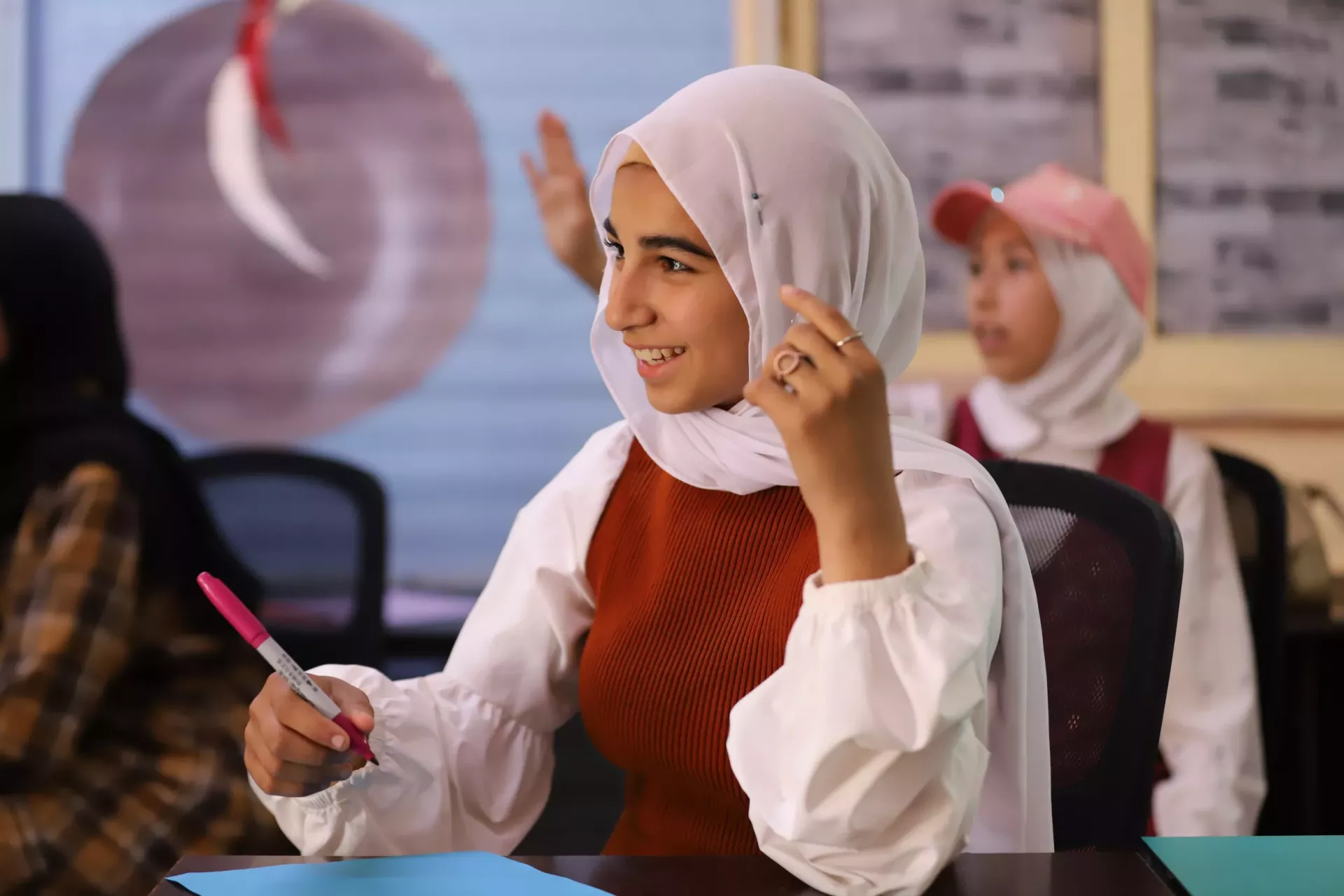 A girl smiling sitting at her desk.