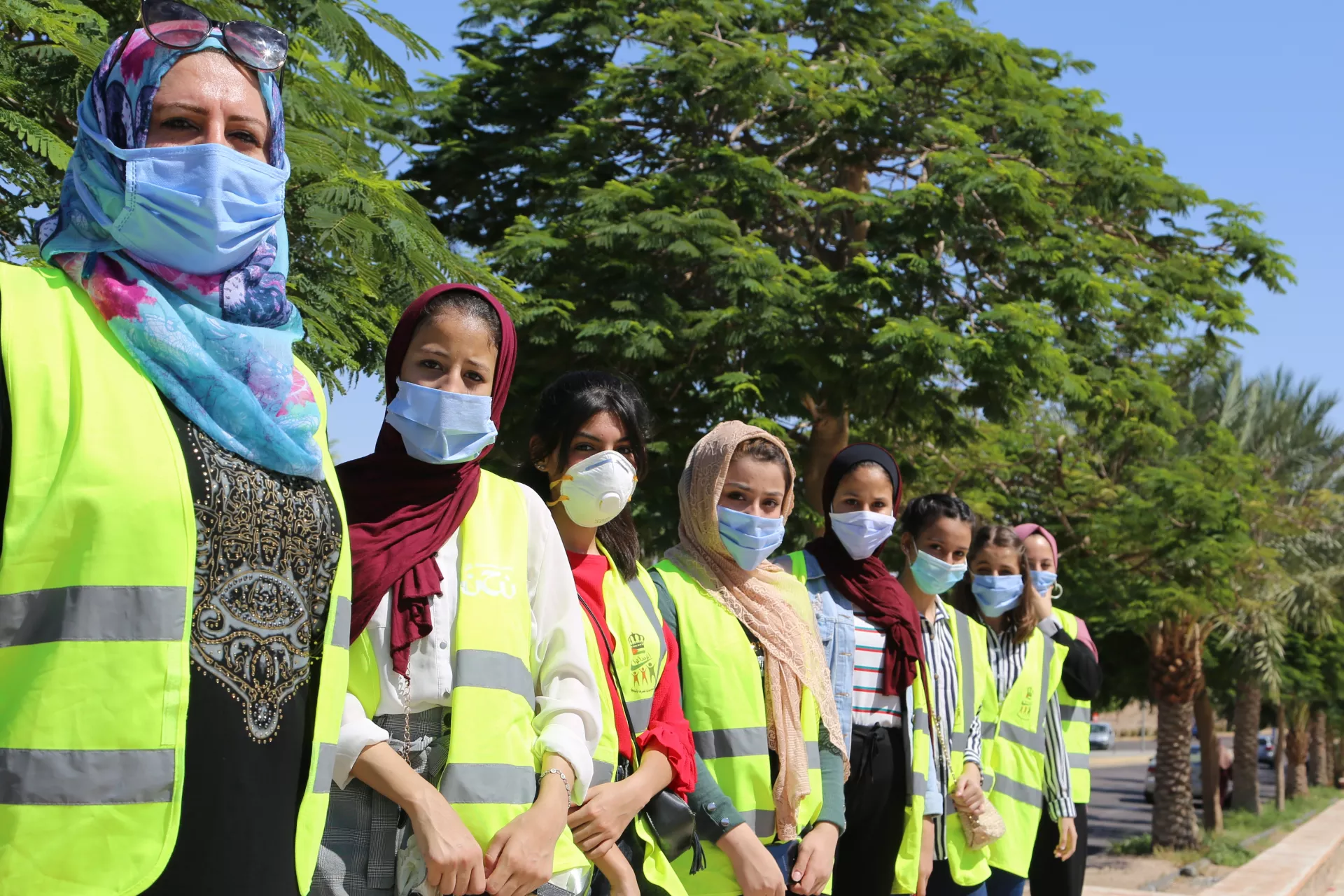 Young volunteers wearing face masks line up