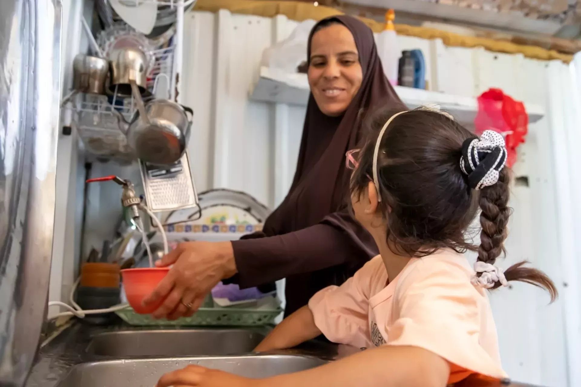 A woman and a girl in a kitchen. 