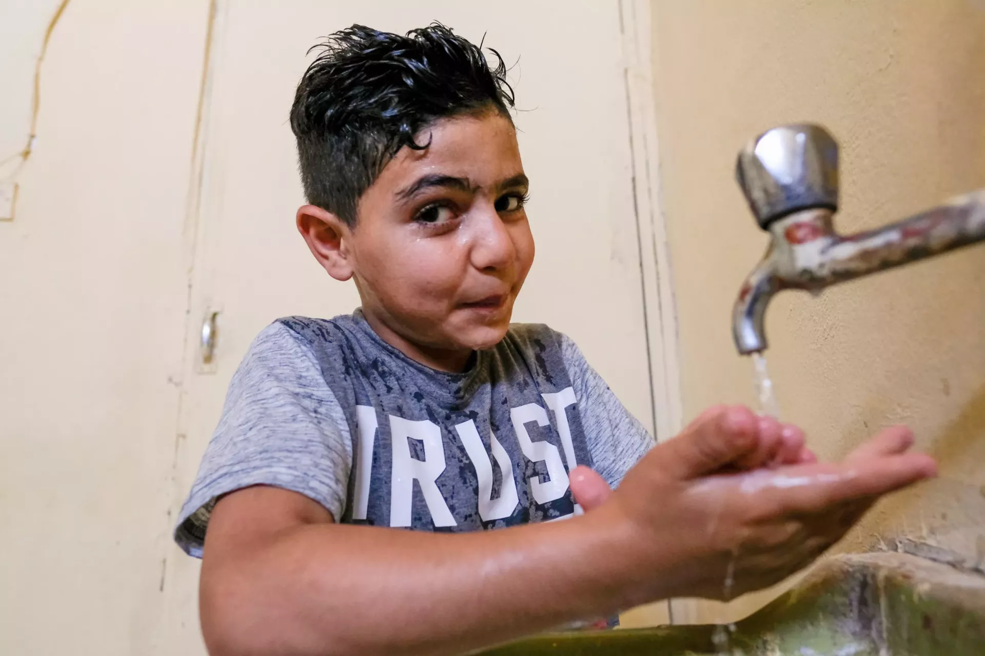 A boy washing his hands.