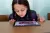 A girl looks at a tablet on a desk