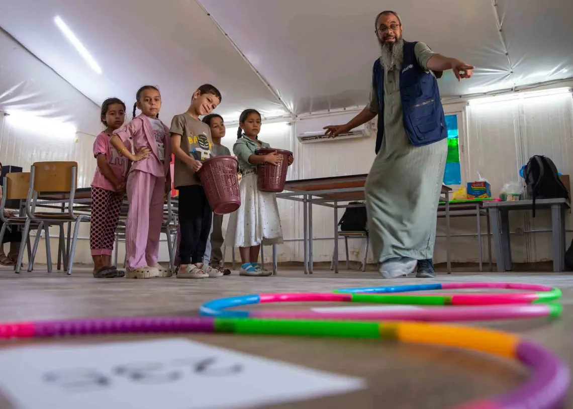 Abu Sham leading the UNICEF-supported Math and Reading Club in the camp