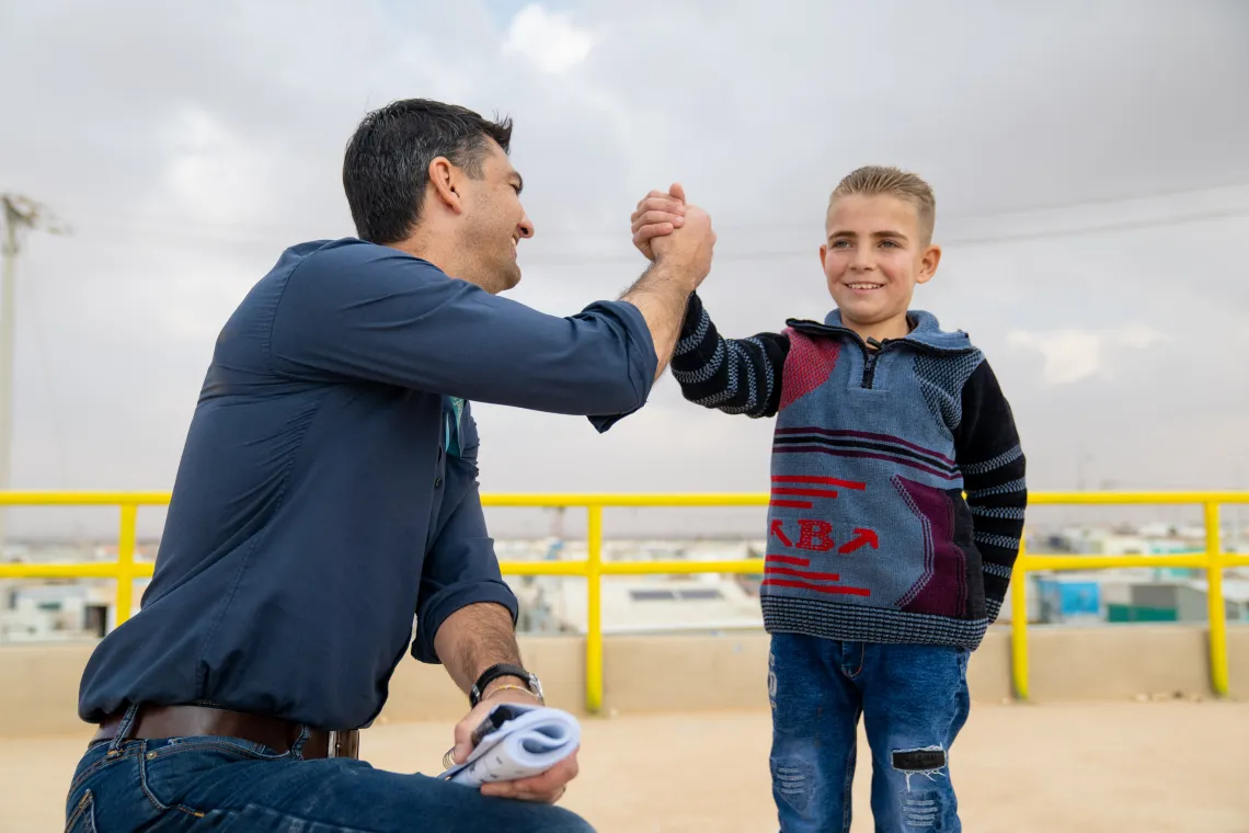 A man shakes hands with a boy