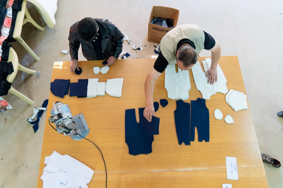Pieces of cloth are cut in a workshop