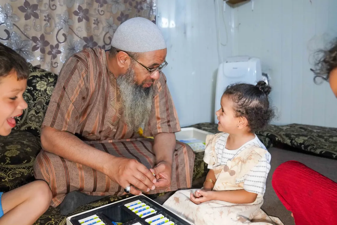 Abu Sham plays a game with his children in his shelter