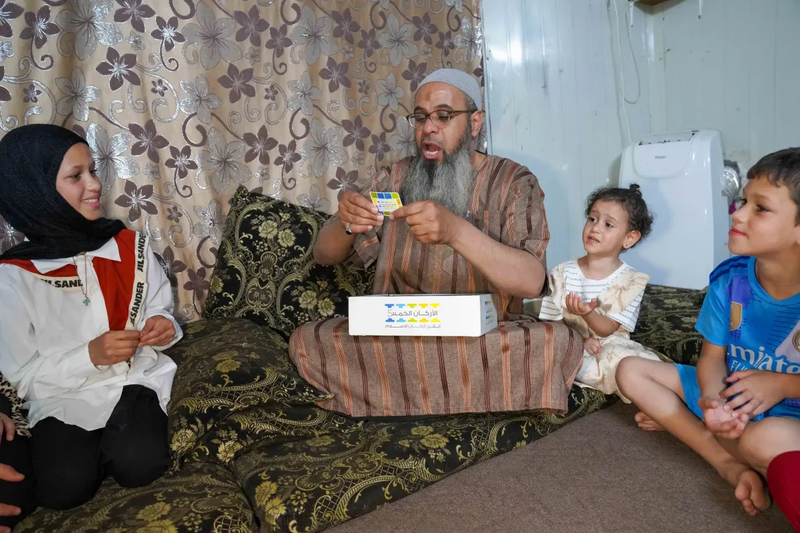 Abu Sham plays a game with his children in his shelter