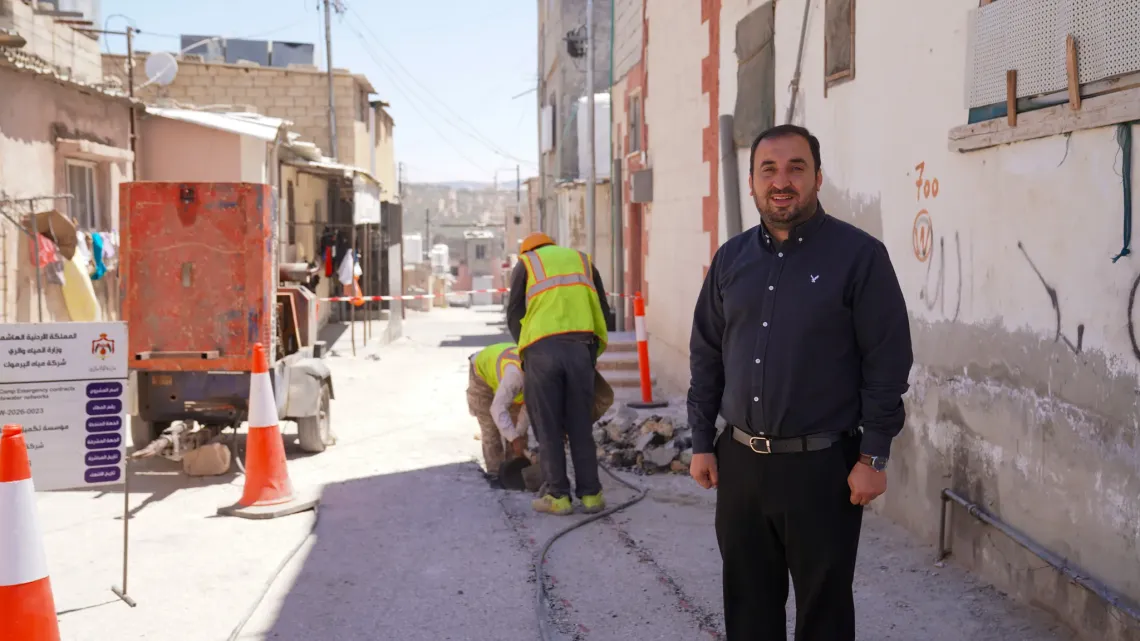 A man standing with maintenance work in the background. 
