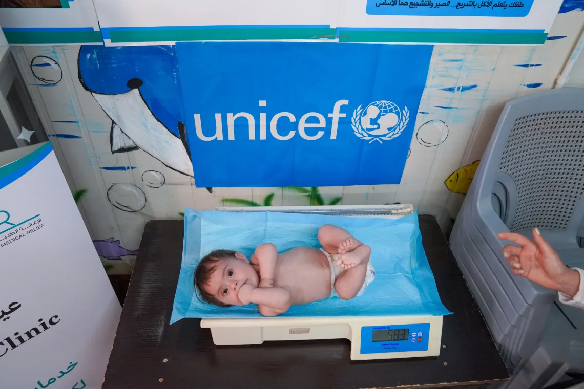 Hasan, 9 months old, being weighed at the Nutrition clinic