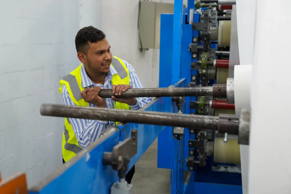 Mohammad, 19, operates a paper production machine