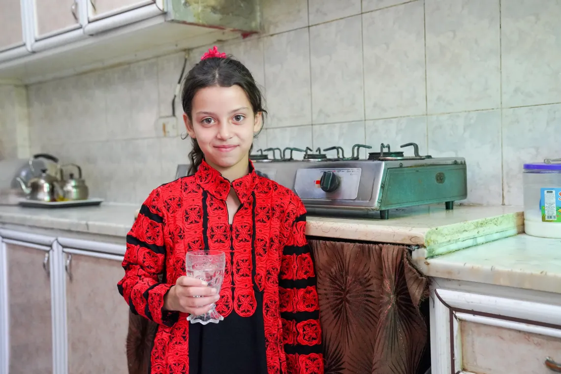 A child holding a cup of water. 