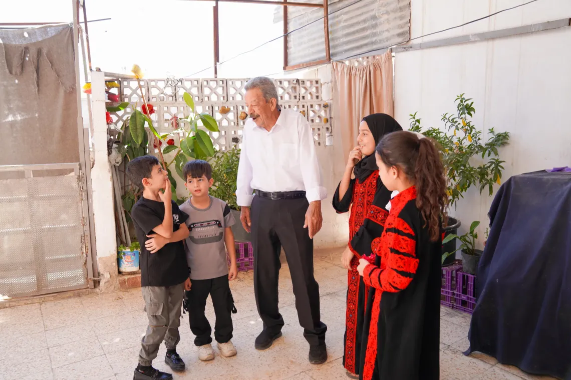 A man standing and surrounded by children. 
