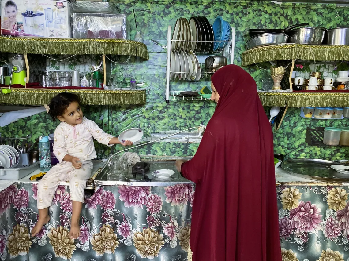 A daughter helping her mom in the kitchen.